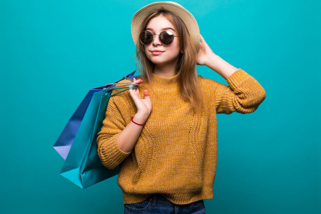 young teen woman sunglasses hat holding shopping bags her hands feeling so happiness isolated green wall 231208 2681